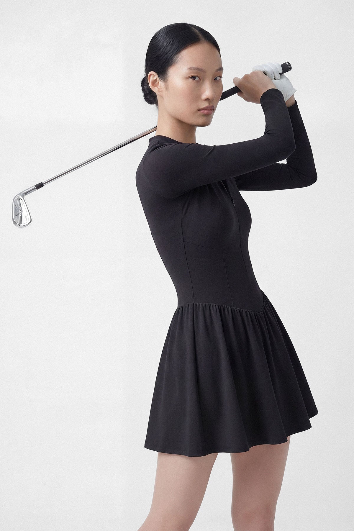 A black long sleeve golf dress with a zipper closure, built-in shorts and a side pocket