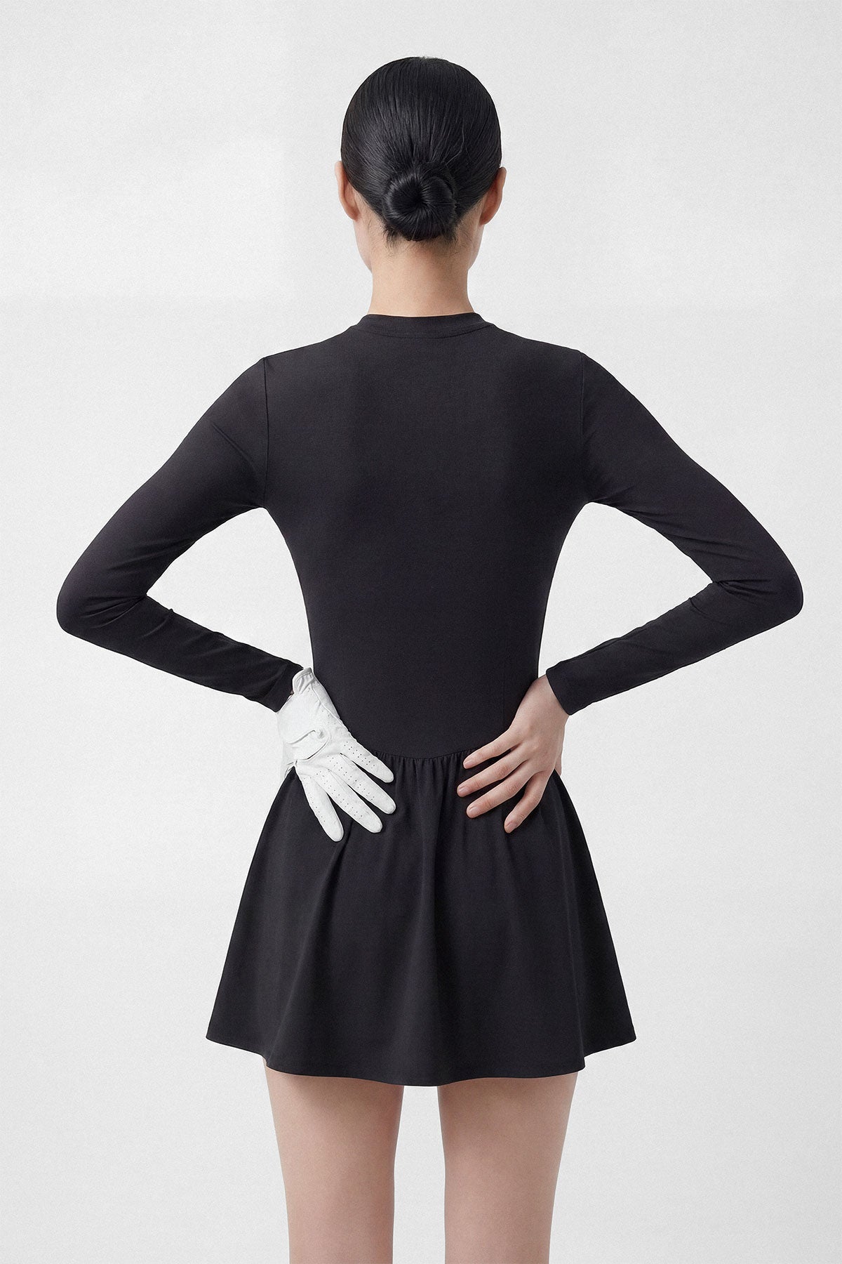 A black long sleeve golf dress with a zipper closure, built-in shorts and a side pocket