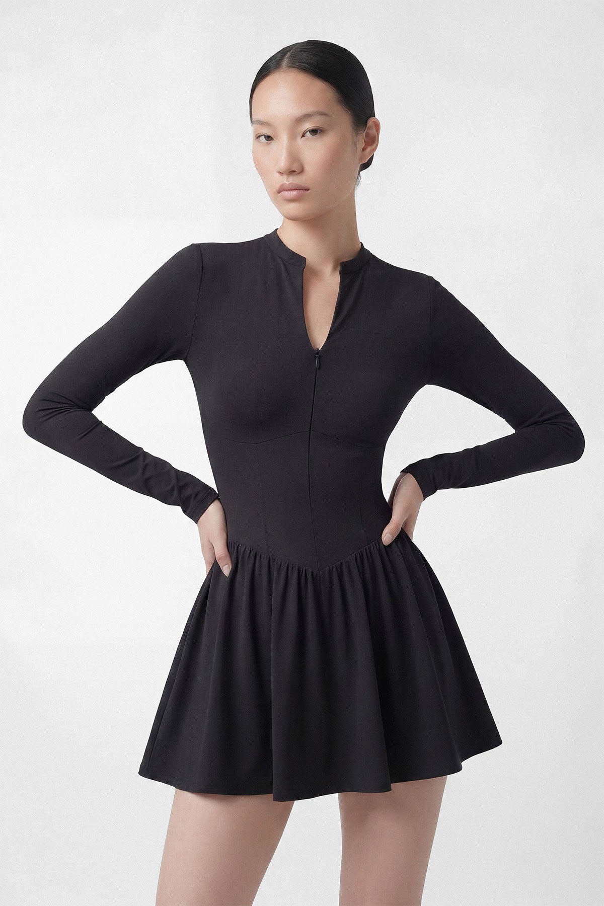 A black long sleeve golf dress with a zipper closure, built-in shorts and a side pocket