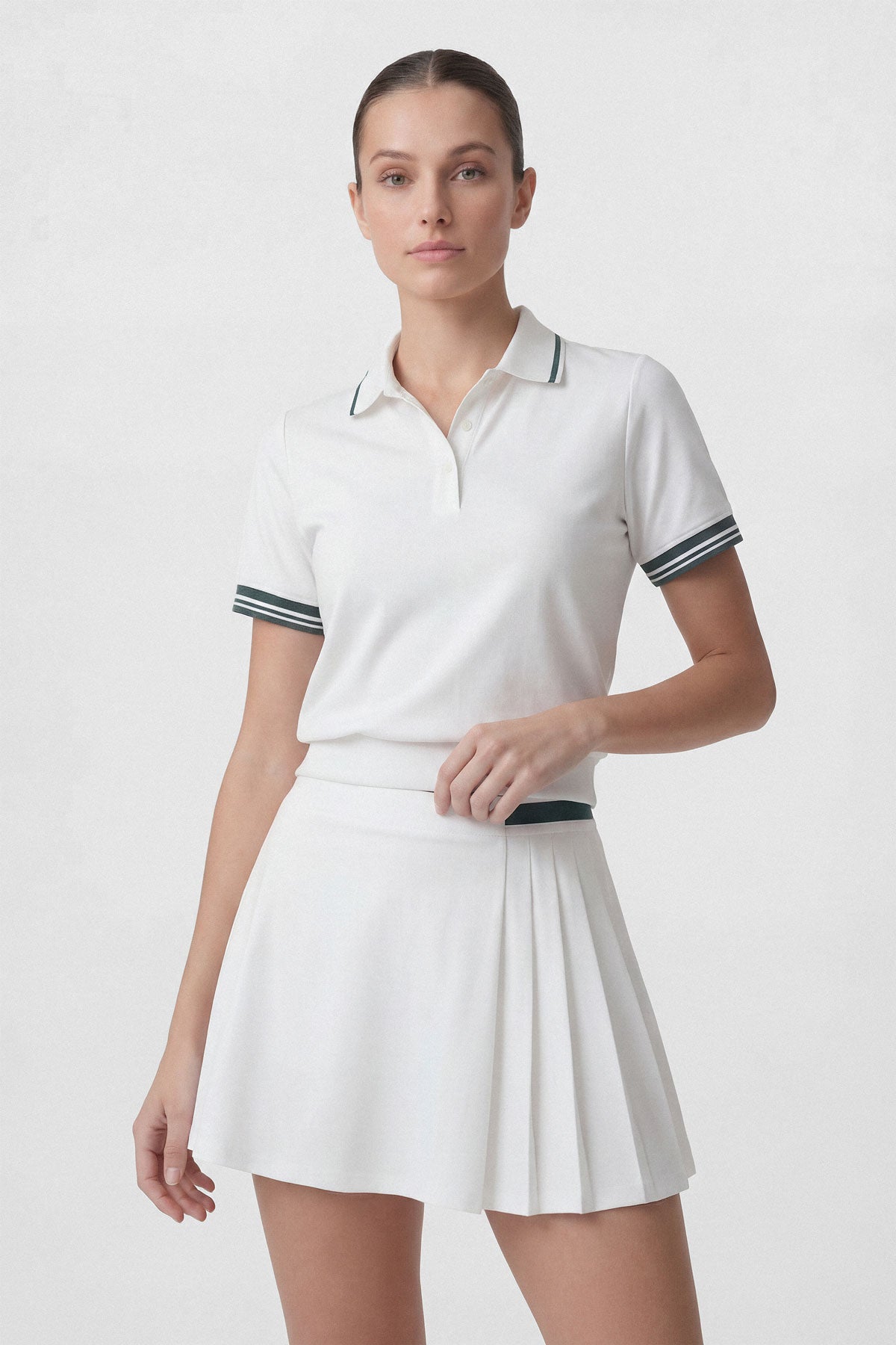 A white women's golf skort with dark green stripe detail and built-in shorts