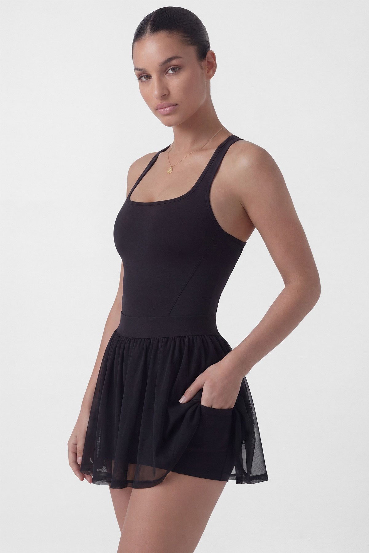Black tennis dress with square neckline, racerback, sculpting bodice, and sheer mesh skirt with built-in shorts