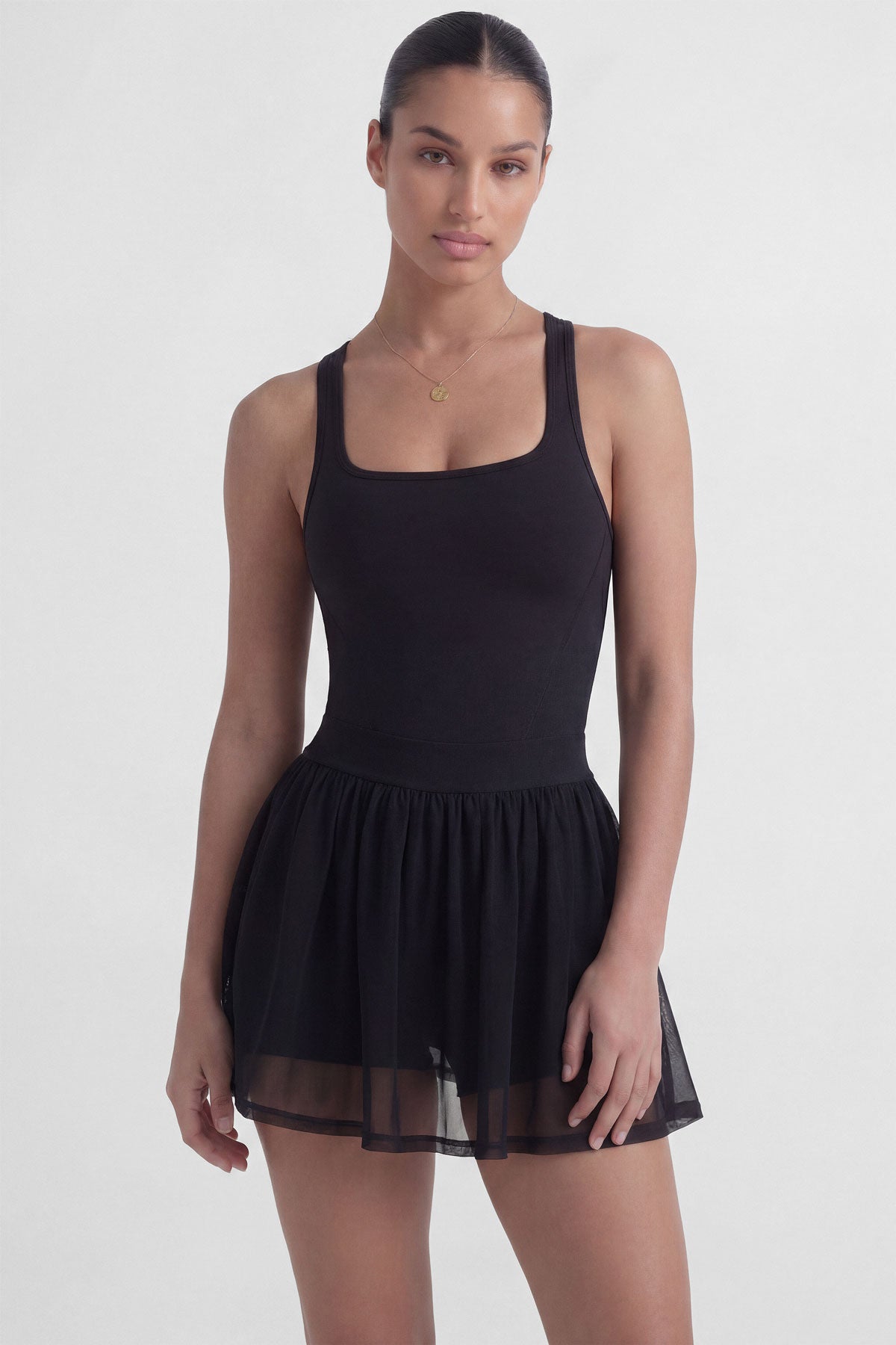 Black tennis dress with square neckline, racerback, sculpting bodice, and sheer mesh skirt with built-in shorts