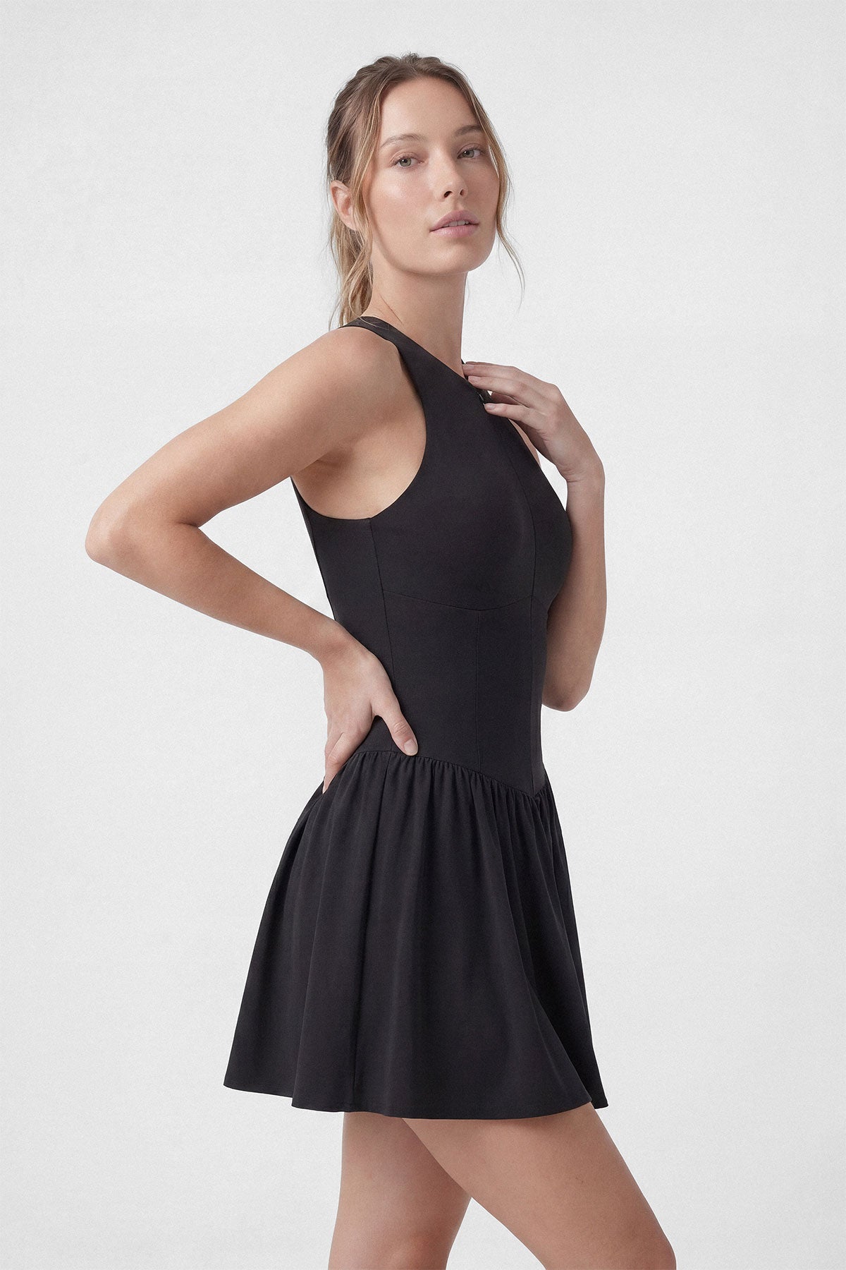 A black sleeveless tennis dress with a zipper closure, built-in shorts and a pocket