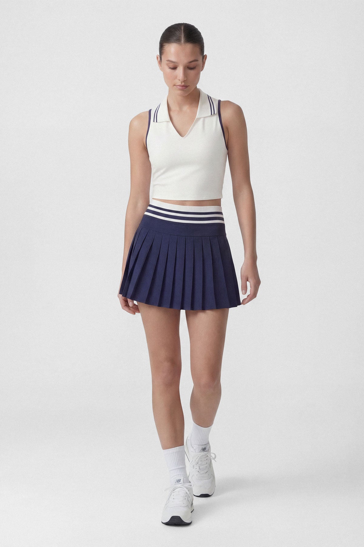 High-wasted navy tennis skirt with a wide striped waistband and built-in shorts