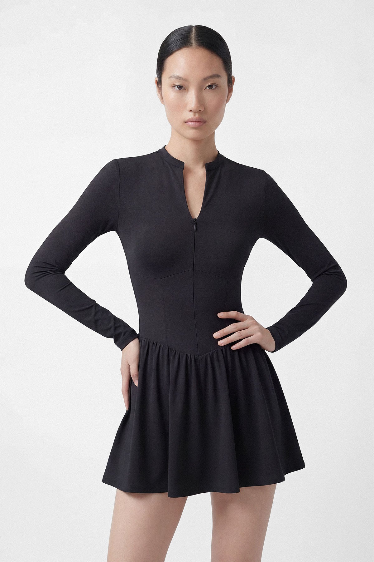 A black long sleeve golf dress with a zipper closure, built-in shorts and a side pocket