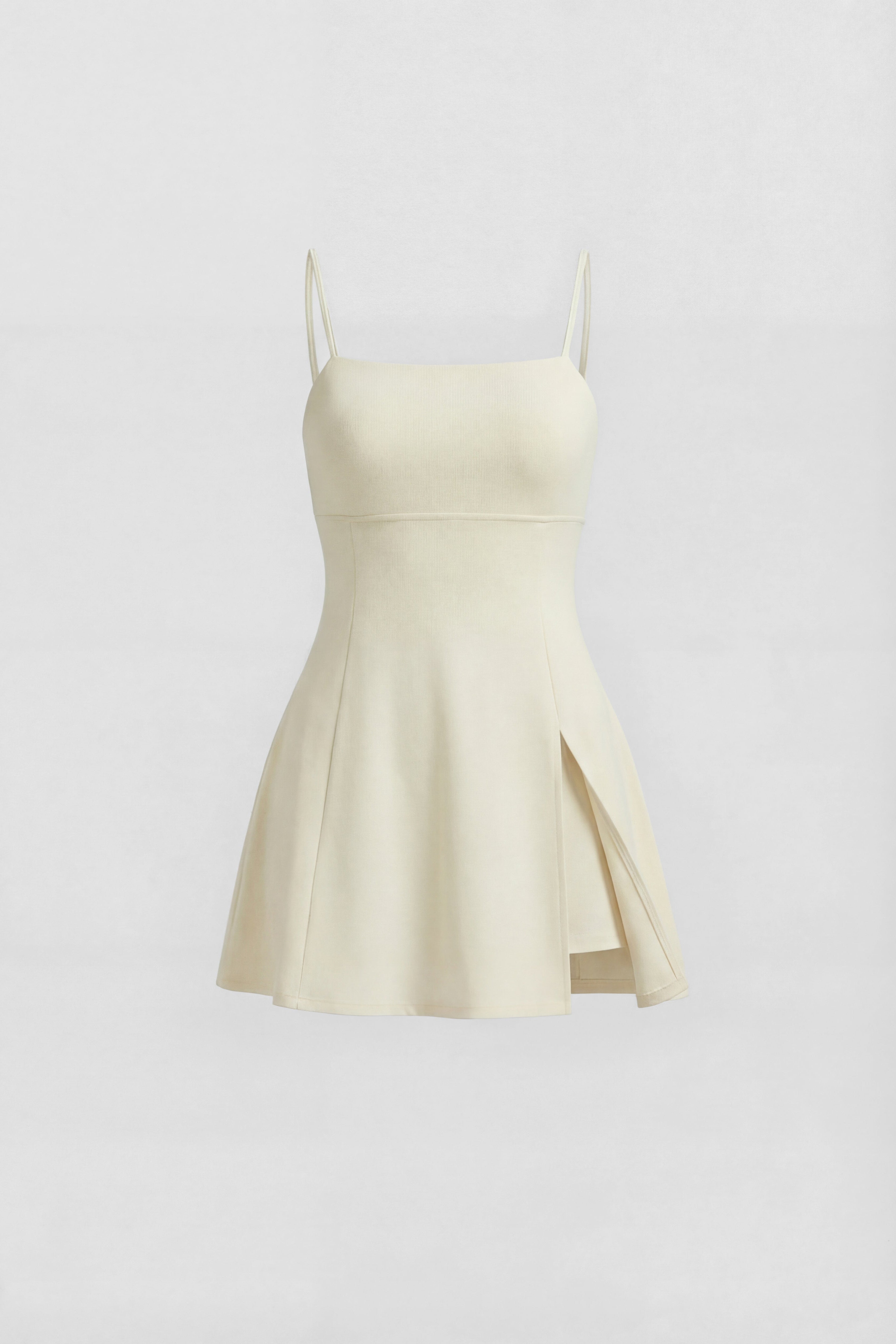 Cream performance tennis dress with a clean square neckline, delicate straps, open back design and a softly flared skirt
