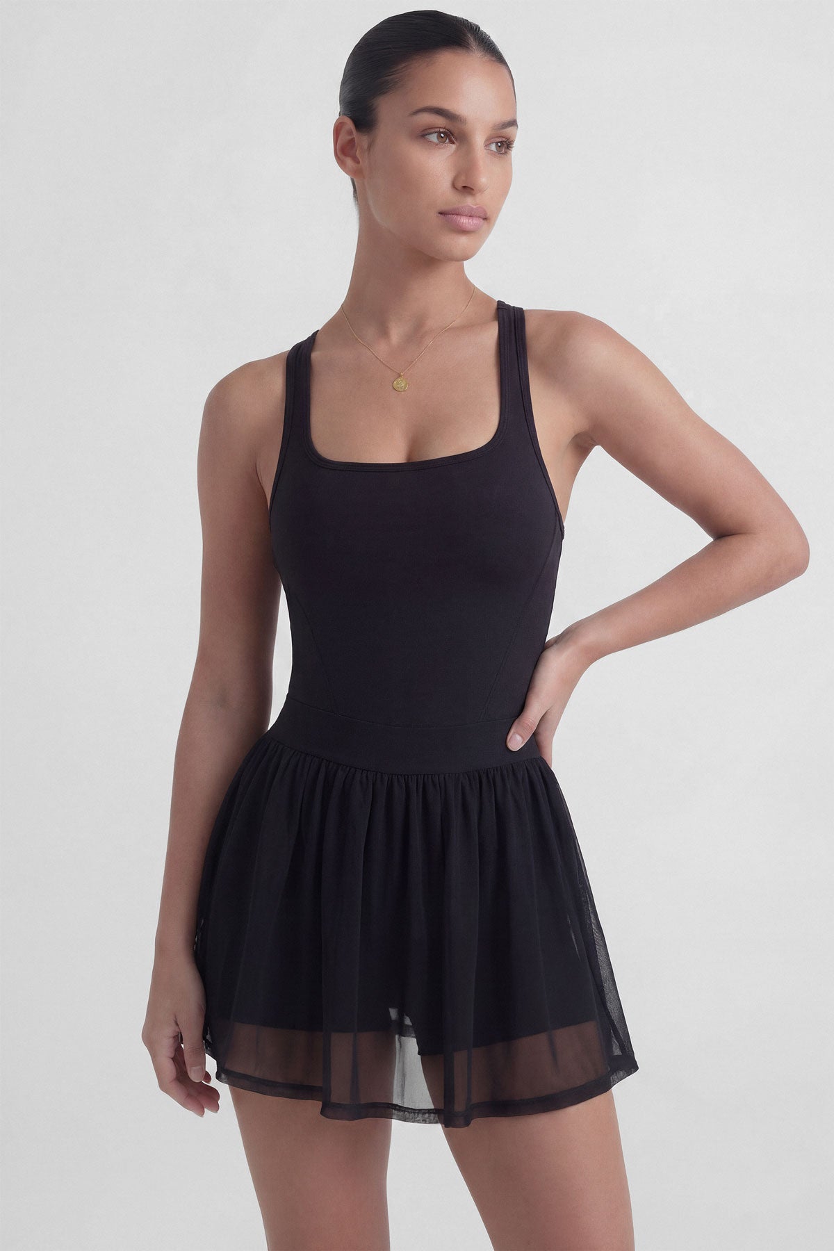 Black tennis dress with square neckline, racerback, sculpting bodice, and sheer mesh skirt with built-in shorts