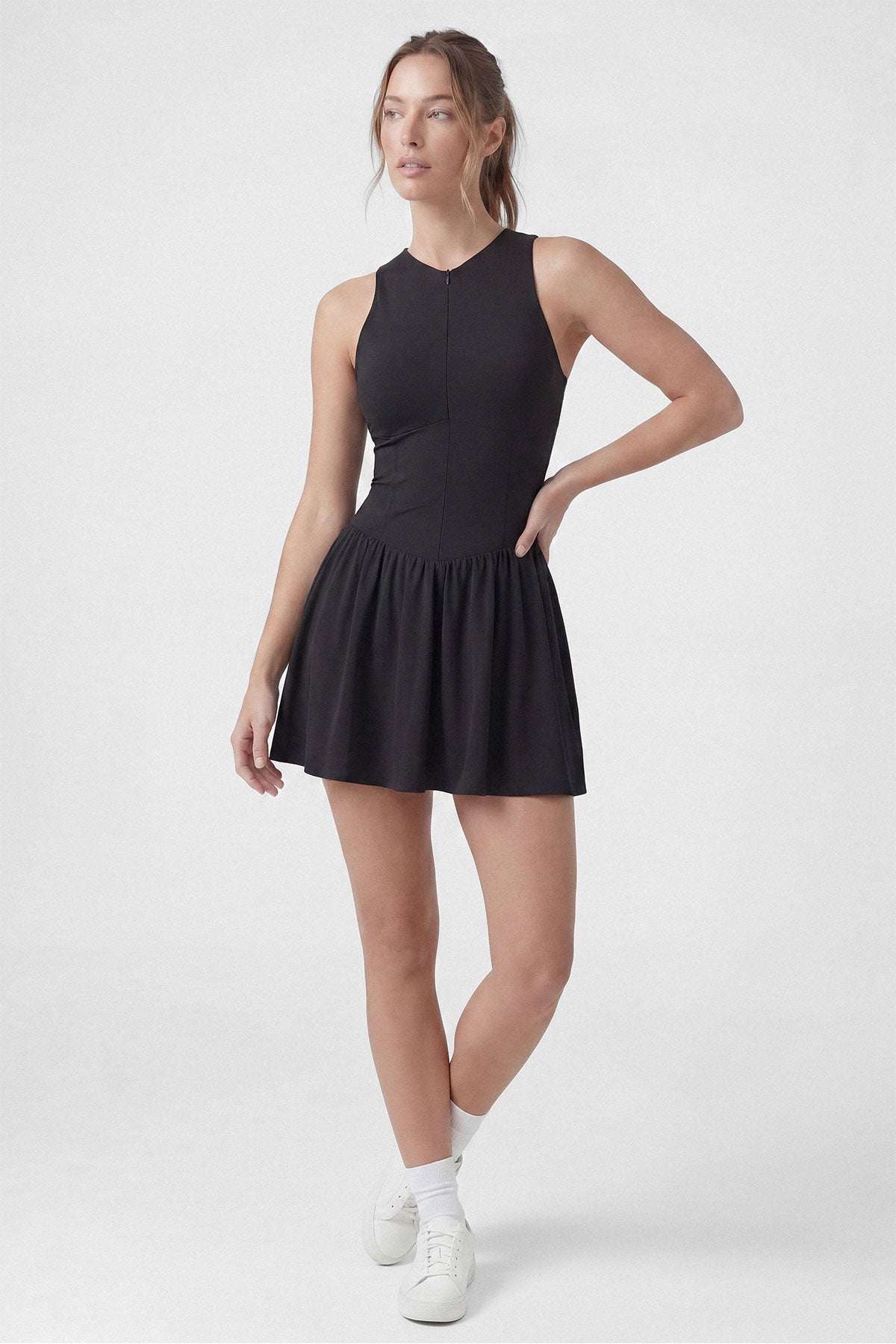 A black sleeveless tennis dress with a zipper closure, built-in shorts and a pocket