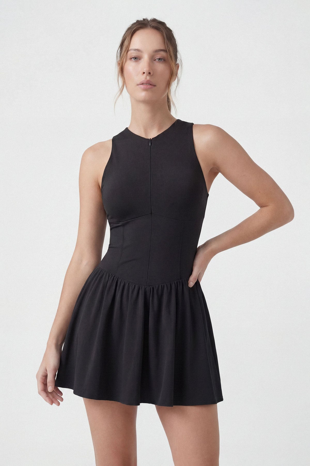 A black sleeveless tennis dress with a zipper closure, built-in shorts and a pocket