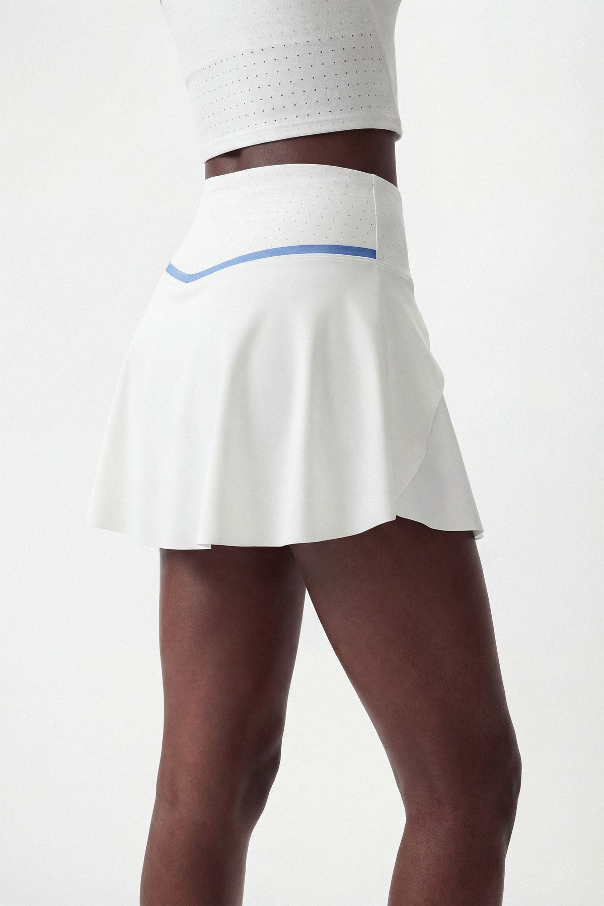 A flattering flared tennis skirt in white with built-in shorts and a side pocket